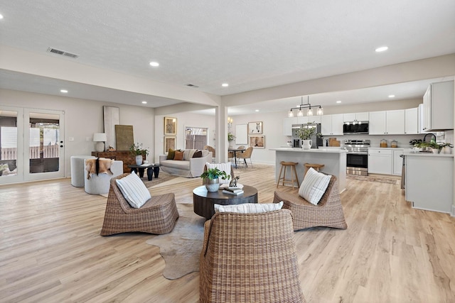 living room with visible vents, recessed lighting, and light wood-style floors