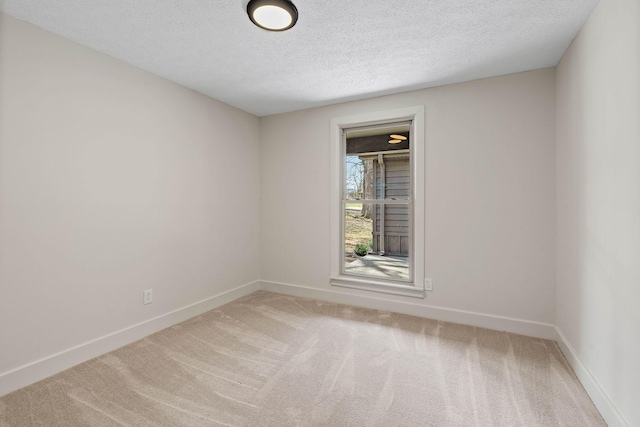 carpeted empty room featuring baseboards and a textured ceiling