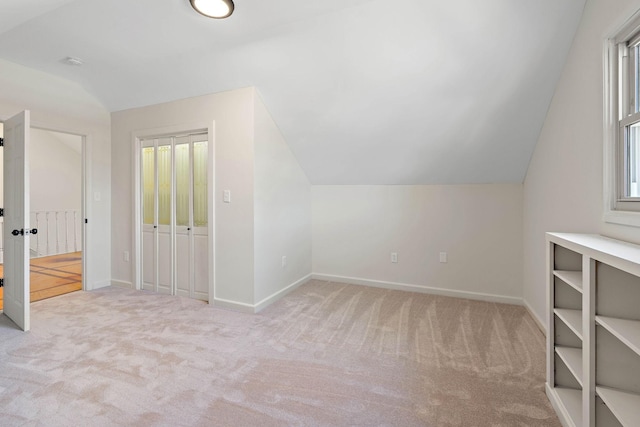 additional living space with lofted ceiling, baseboards, carpet, and plenty of natural light