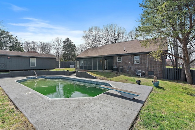 view of pool featuring a fenced backyard, a yard, a patio, a fenced in pool, and a sunroom