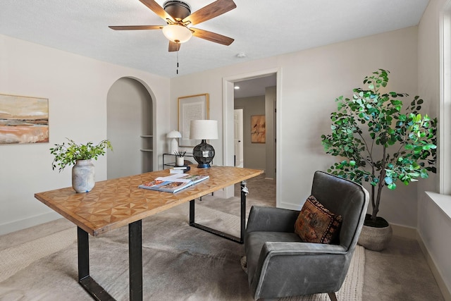 office featuring arched walkways, carpet floors, a ceiling fan, and baseboards