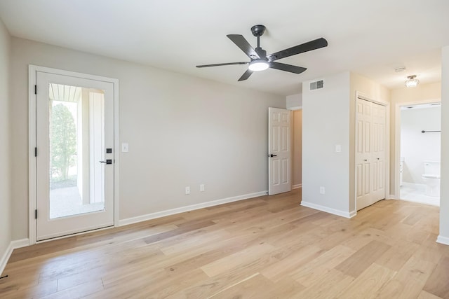 unfurnished bedroom with baseboards, light wood-style floors, visible vents, and ensuite bathroom
