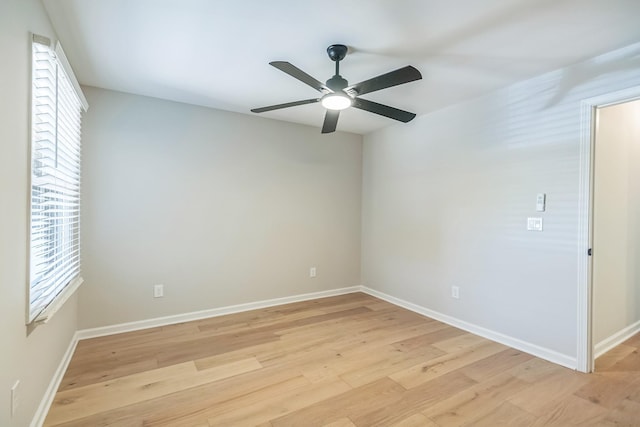 empty room featuring light wood-type flooring, a ceiling fan, and baseboards