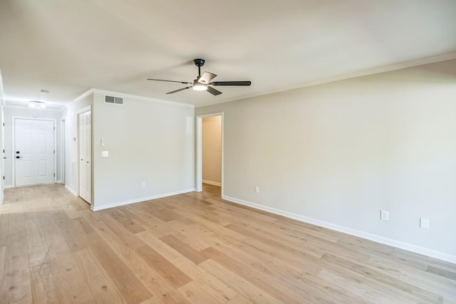 spare room with light wood-type flooring, baseboards, visible vents, a ceiling fan, and crown molding