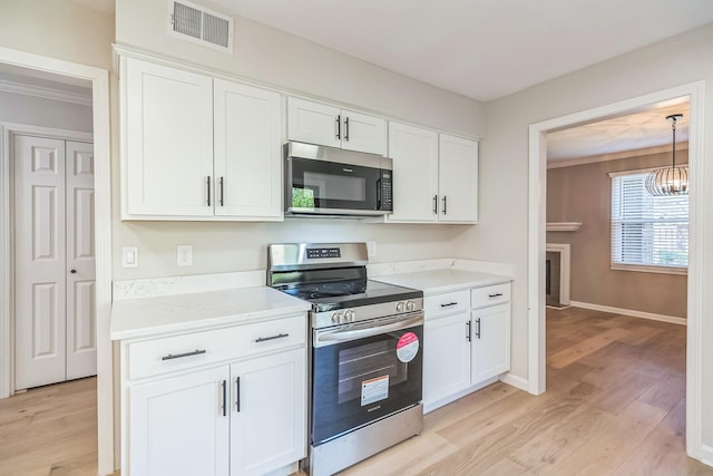 kitchen with white cabinets, light countertops, visible vents, light wood-type flooring, and appliances with stainless steel finishes