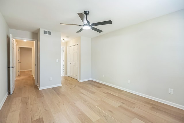 unfurnished bedroom featuring baseboards, a closet, visible vents, and light wood-type flooring