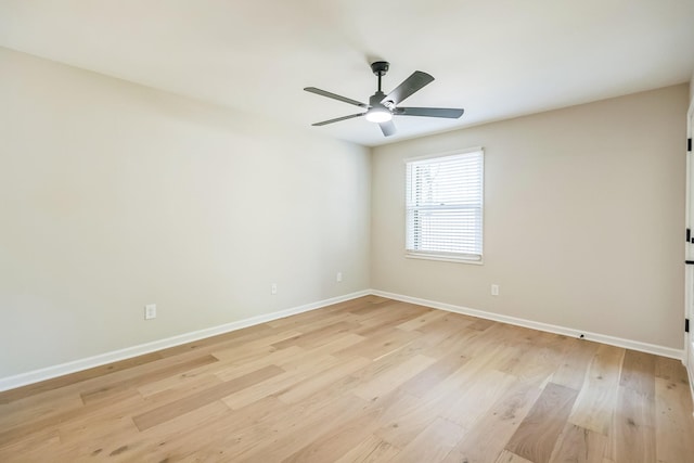 spare room with light wood finished floors, a ceiling fan, and baseboards