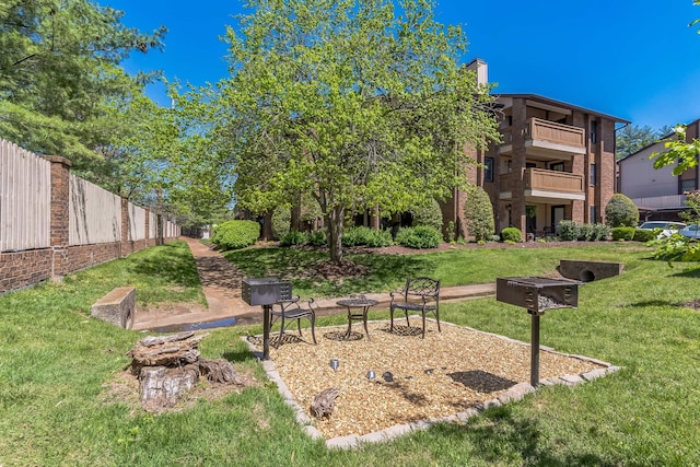 view of community with fence and a lawn