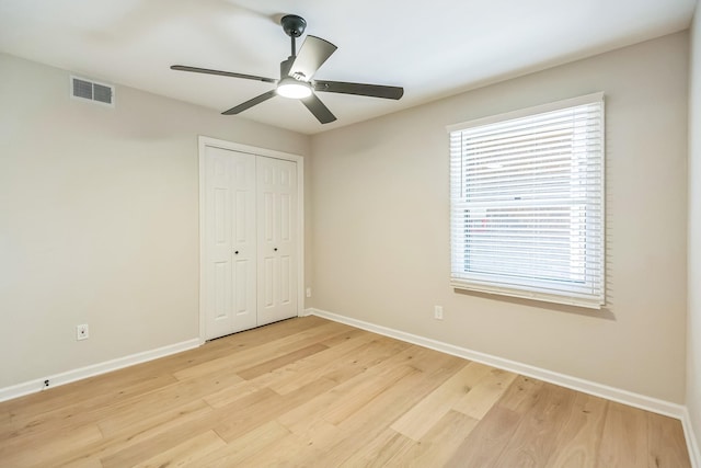 unfurnished bedroom with light wood-type flooring, visible vents, and baseboards