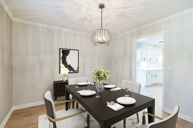 dining area with a chandelier, light wood-style flooring, crown molding, and baseboards