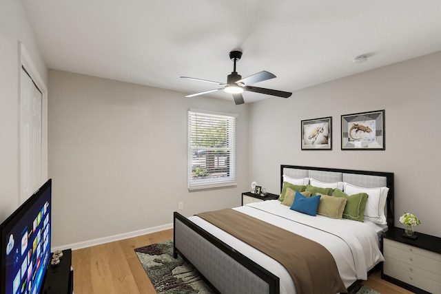 bedroom featuring baseboards, a ceiling fan, and light wood-style flooring