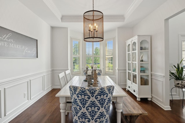 dining room featuring a decorative wall, a chandelier, dark wood-type flooring, a tray ceiling, and ornamental molding