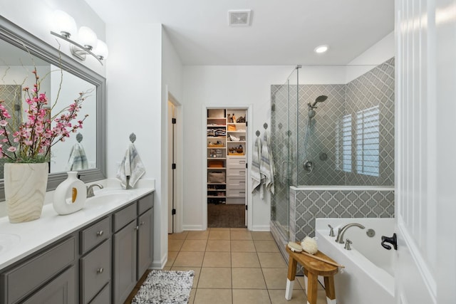 bathroom featuring a shower stall, tile patterned flooring, a bath, a spacious closet, and vanity