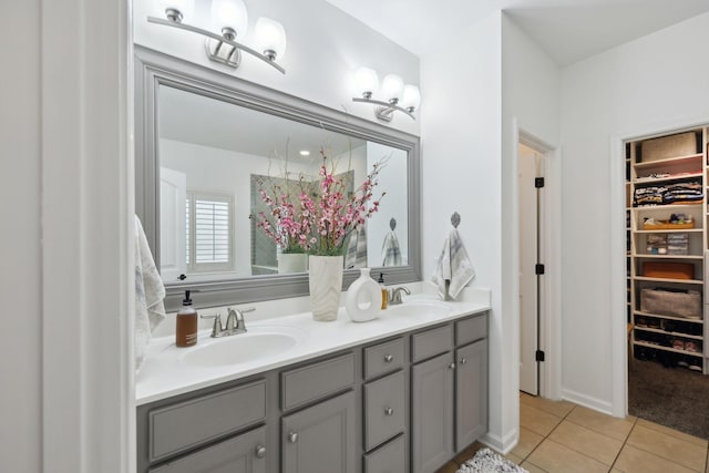 bathroom featuring tile patterned flooring, a walk in closet, and double vanity