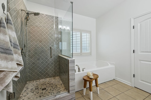 bathroom with tile patterned floors, a bath, and a shower stall