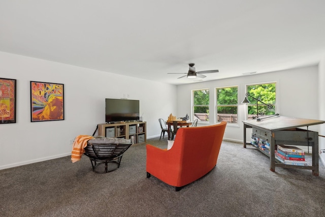 carpeted living room featuring a ceiling fan and baseboards