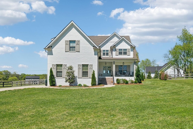 view of front of home with fence, a front lawn, covered porch, and board and batten siding