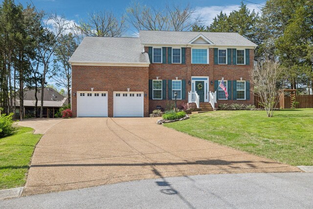 313 Walpole Ct, Nolensville, TN 37135 - colonial house with concrete driveway, fence, a front yard, a garage, and brick siding