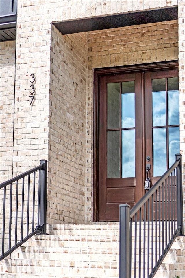view of exterior entry featuring brick siding