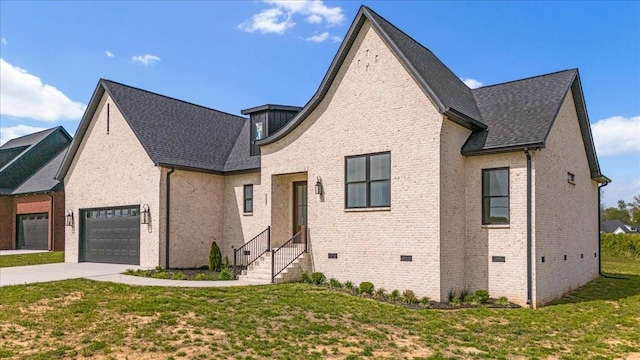 view of front of house with an attached garage, driveway, brick siding, and a front yard