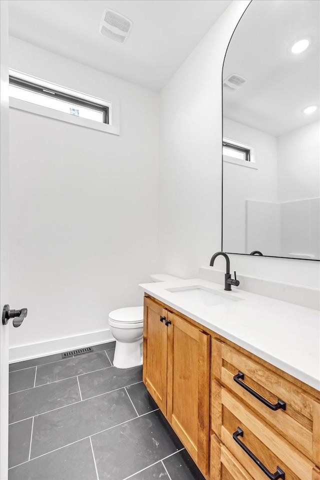 bathroom with toilet, baseboards, visible vents, tile patterned flooring, and vanity