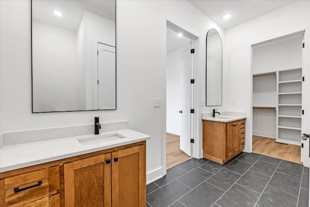 bathroom featuring two vanities, tile patterned floors, a sink, and recessed lighting