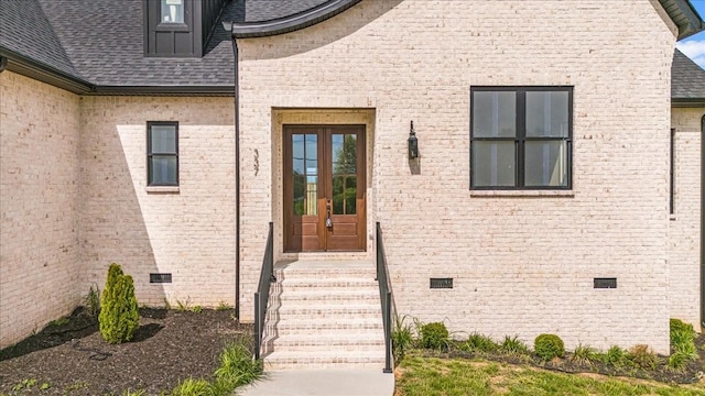 property entrance with brick siding, crawl space, and a shingled roof