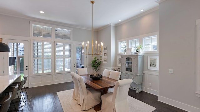 dining area with a decorative wall, ornamental molding, a chandelier, and dark wood-type flooring