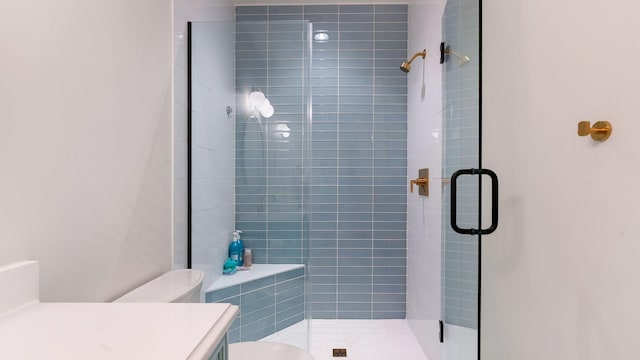 bathroom with a shower stall, toilet, and vanity