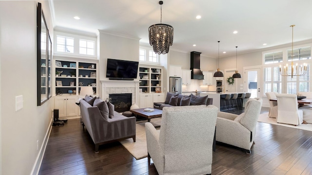 living room with a fireplace, crown molding, dark wood-style flooring, and an inviting chandelier