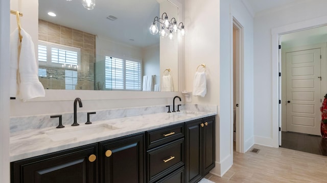 full bathroom with ornamental molding, baseboards, a sink, and double vanity