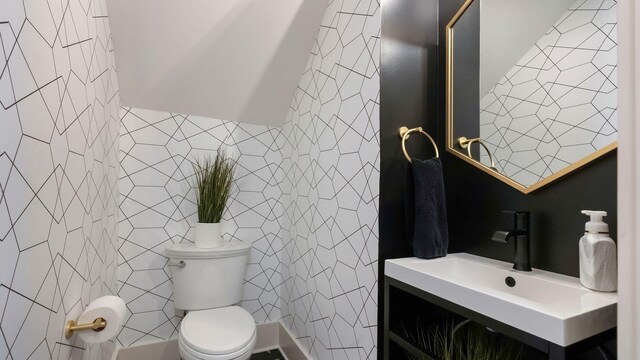 bathroom featuring toilet, vanity, and tile walls