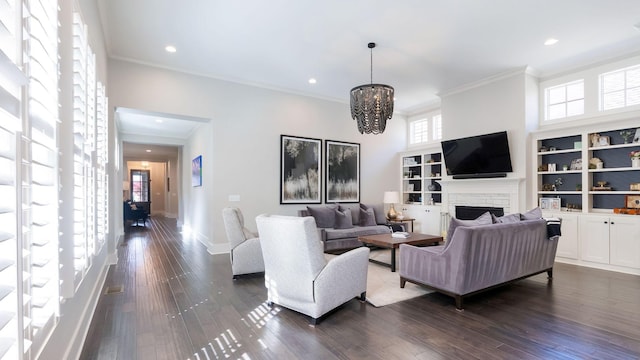 living room with dark wood-style flooring, baseboards, an inviting chandelier, a fireplace, and ornamental molding