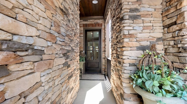 doorway to property with stone siding