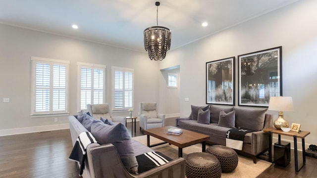 living area featuring baseboards, crown molding, hardwood / wood-style floors, and an inviting chandelier