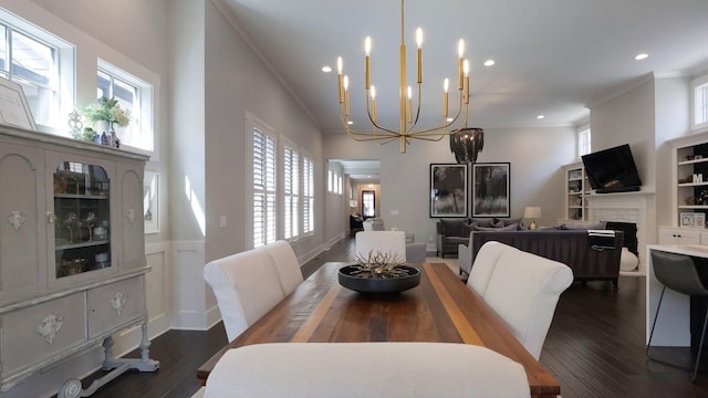 dining space featuring recessed lighting, dark wood-type flooring, crown molding, a fireplace, and a notable chandelier