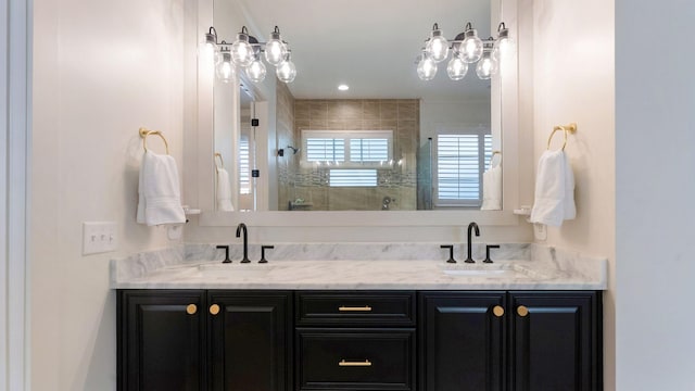 bathroom with a sink, double vanity, and tiled shower