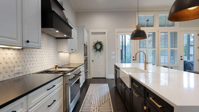kitchen with a sink, white cabinetry, backsplash, custom range hood, and appliances with stainless steel finishes