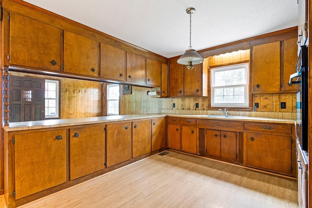 4103 Arno Rd, Franklin, TN 37064 - kitchen with a sink, light wood-type flooring, brown cabinetry, light countertops, and hanging light fixtures