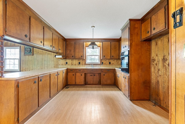 4103 Arno Rd, Franklin, TN 37064 - kitchen featuring brown cabinetry, oven, light wood-style flooring, pendant lighting, and light countertops