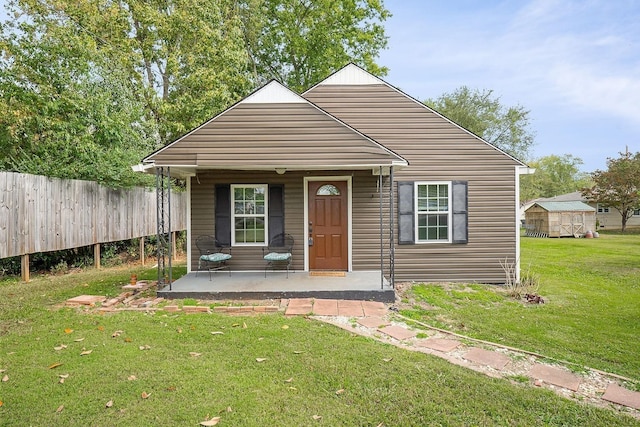 212 Mullican St, Mcminnville, TN 37110 - view of front of house featuring fence, a front lawn, and covered porch