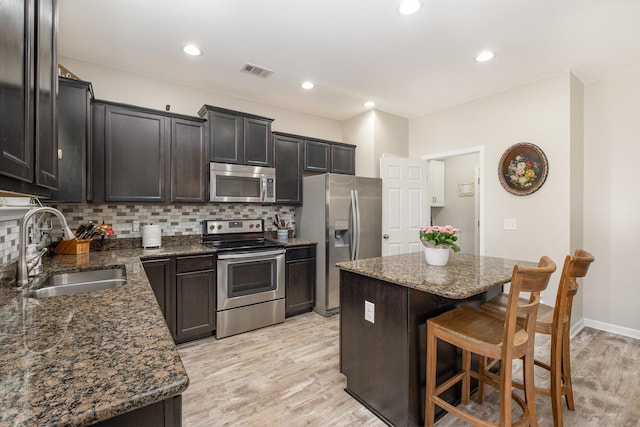 1517 Rockwood Ln, Lebanon, TN 37087 - kitchen with a sink, light wood-type flooring, visible vents, appliances with stainless steel finishes, and a breakfast bar area