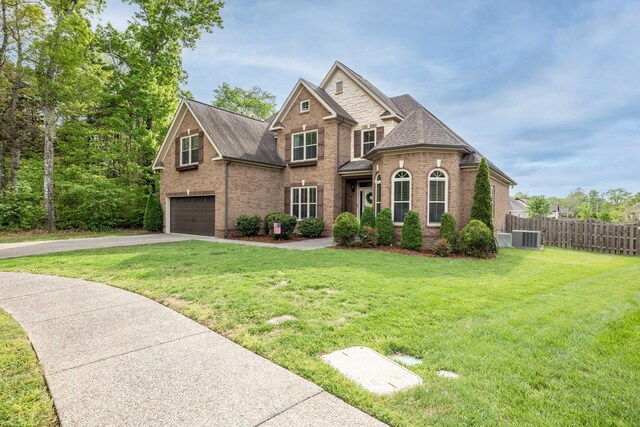 1026 Claymill Dr, Spring Hill, TN 37174 - craftsman house featuring fence, a front lawn, an attached garage, driveway, and brick siding