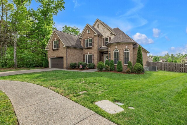 1026 Claymill Dr, Spring Hill, TN 37174 - view of front of home with fence, roof with shingles, an attached garage, driveway, and brick siding