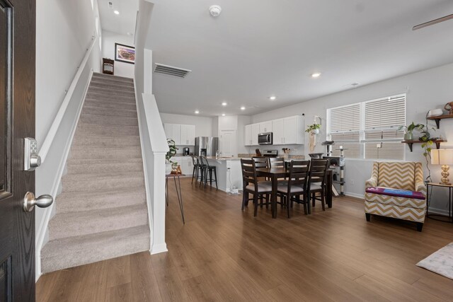 dining space with baseboards, visible vents, recessed lighting, stairs, and dark wood-type flooring