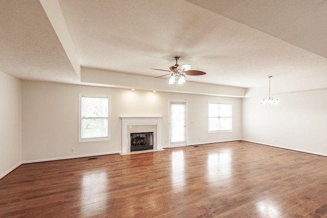 327 Arabian Ln, Springfield, TN 37172 - unfurnished living room with a fireplace, a healthy amount of sunlight, wood finished floors, and ceiling fan with notable chandelier