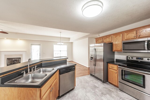 327 Arabian Ln, Springfield, TN 37172 - kitchen featuring dark countertops, a sink, brown cabinets, stainless steel appliances, and decorative light fixtures