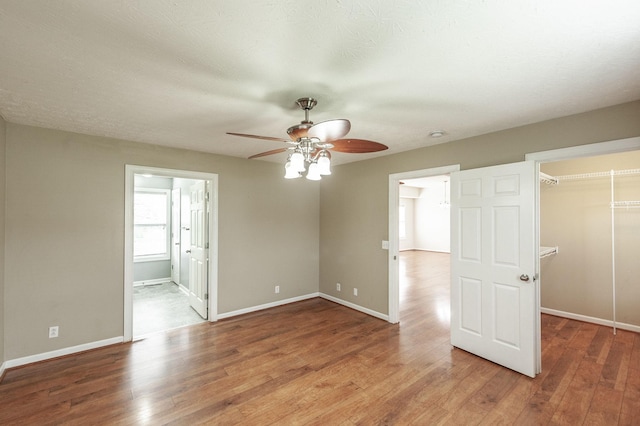 327 Arabian Ln, Springfield, TN 37172 - unfurnished bedroom featuring light wood finished floors, a walk in closet, a closet, ensuite bath, and baseboards