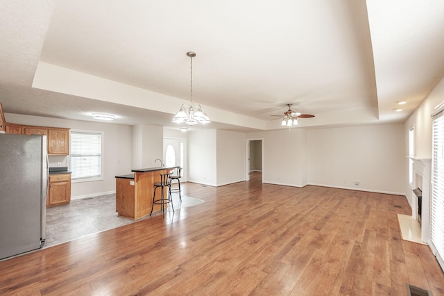 327 Arabian Ln, Springfield, TN 37172 - interior space featuring dark countertops, ceiling fan with notable chandelier, light wood-type flooring, visible vents, and freestanding refrigerator