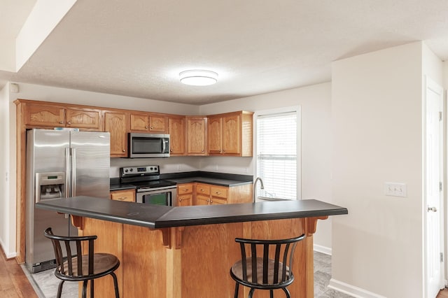 327 Arabian Ln, Springfield, TN 37172 - kitchen with a kitchen bar, baseboards, dark countertops, and stainless steel appliances